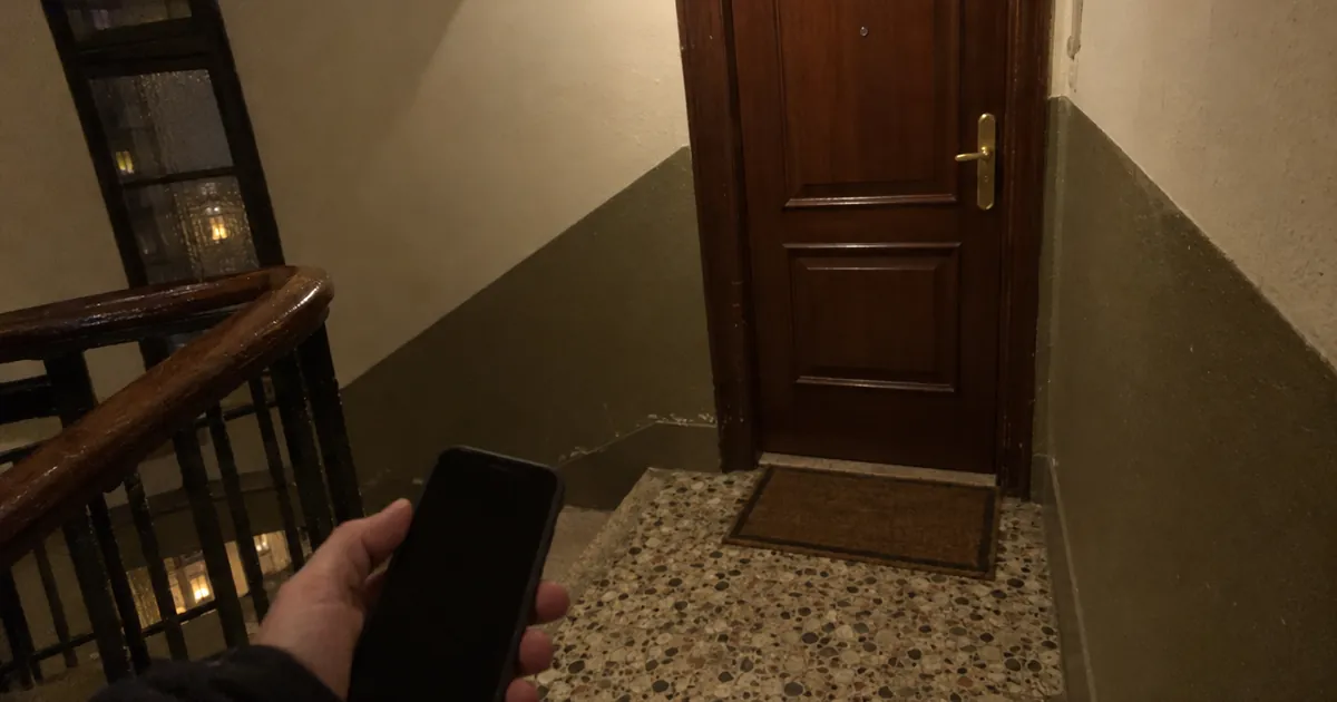 Puerta de entrada de un piso cerrada vista desde el rellano de la escalera