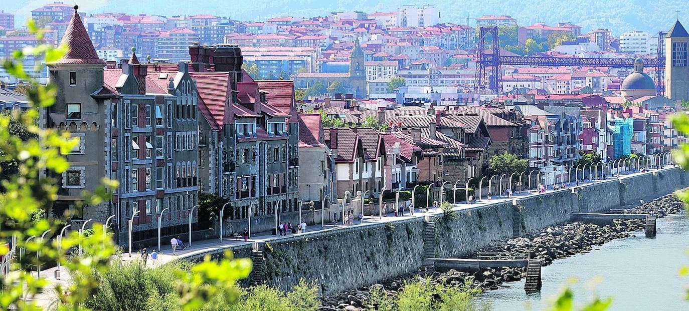 Hilera de casas de tejados rojos sobre un muelle de piedra junto al agua