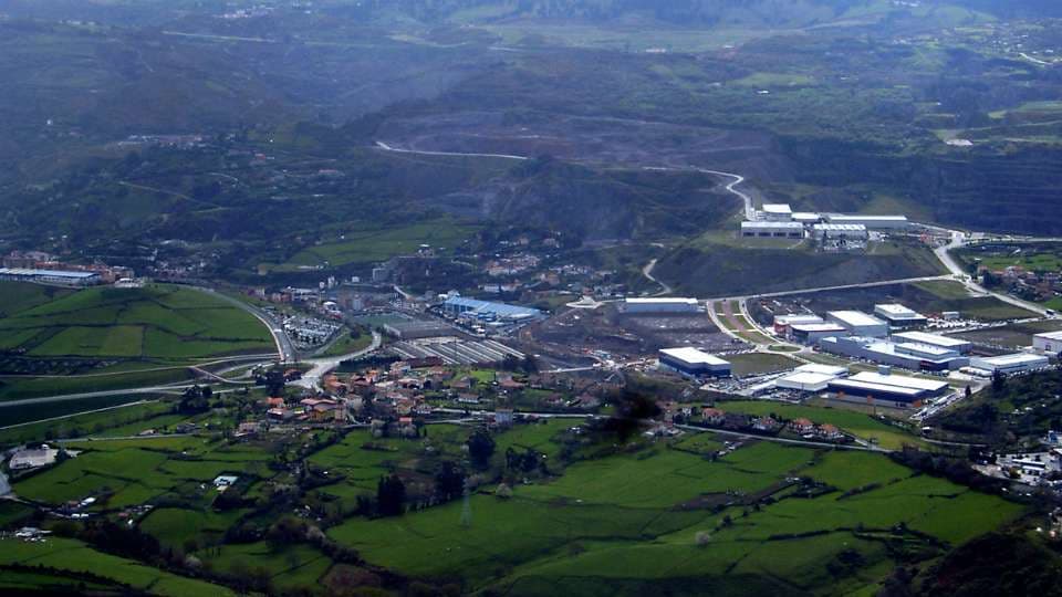Valle verde de Ortuella con naves y carreteras entre los montes